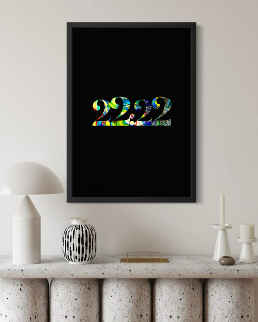 A framed wall art print featuring the number 222 in a colorful tie-dye pattern on a black background, displayed in a modern living room setting above a stone mantel with decorative objects.