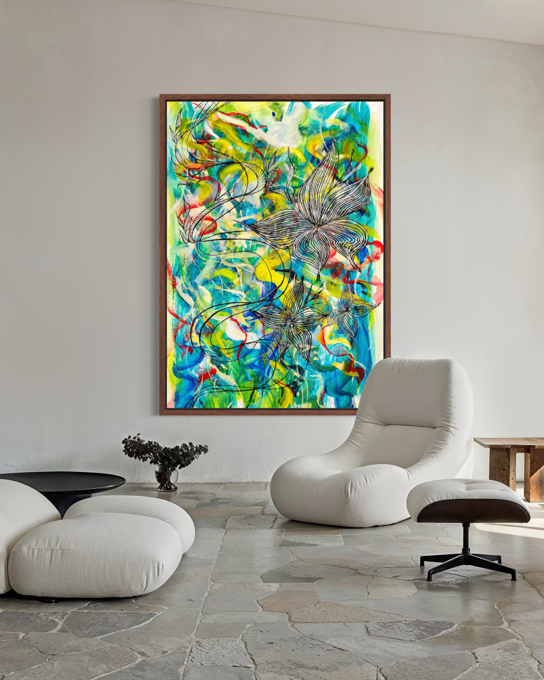 A large framed abstract painting with vibrant blue, green, yellow, and red brushstrokes hangs on a light gray wall in a modern living room setting with a white lounge chair and stone tile floor.