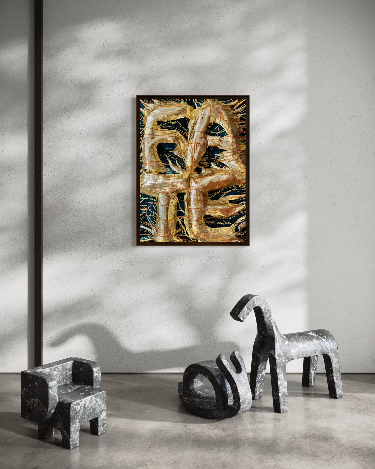 A framed abstract painting featuring textured gold and black brushstrokes hangs on a light gray wall in a modern interior setting with sculptural chairs and a concrete floor.